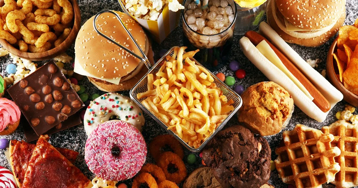 Various ultra-processed foods arranged on a dark surface